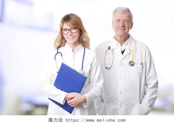 手里拿着剪贴板的中年女医生站在私人诊所的高级专业男子旁边